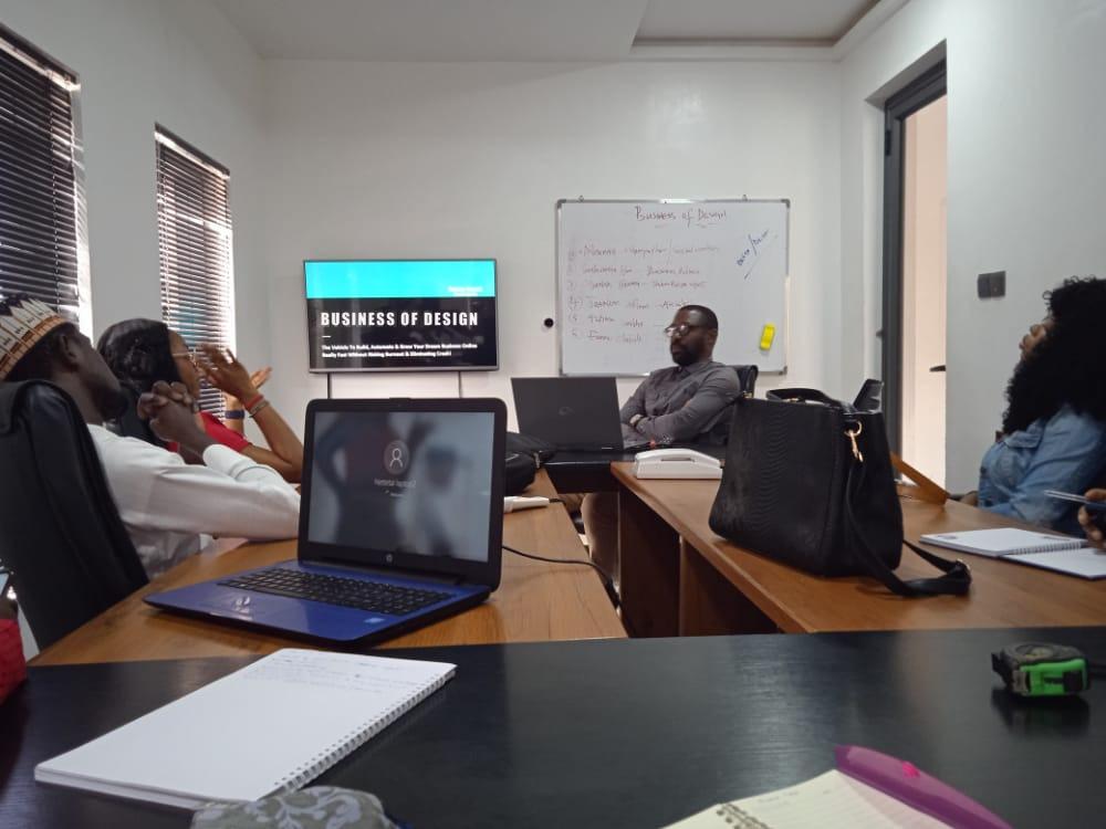 A class of owners and operators taught by Raman Arunsi, notebooks and laptops open around the table